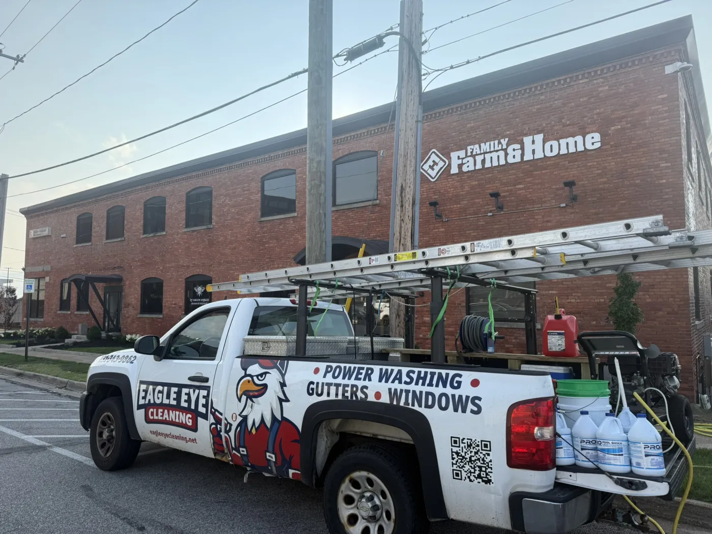Eagle Eye Cleaning branded service truck equipped with ladders and pressure washing gear
