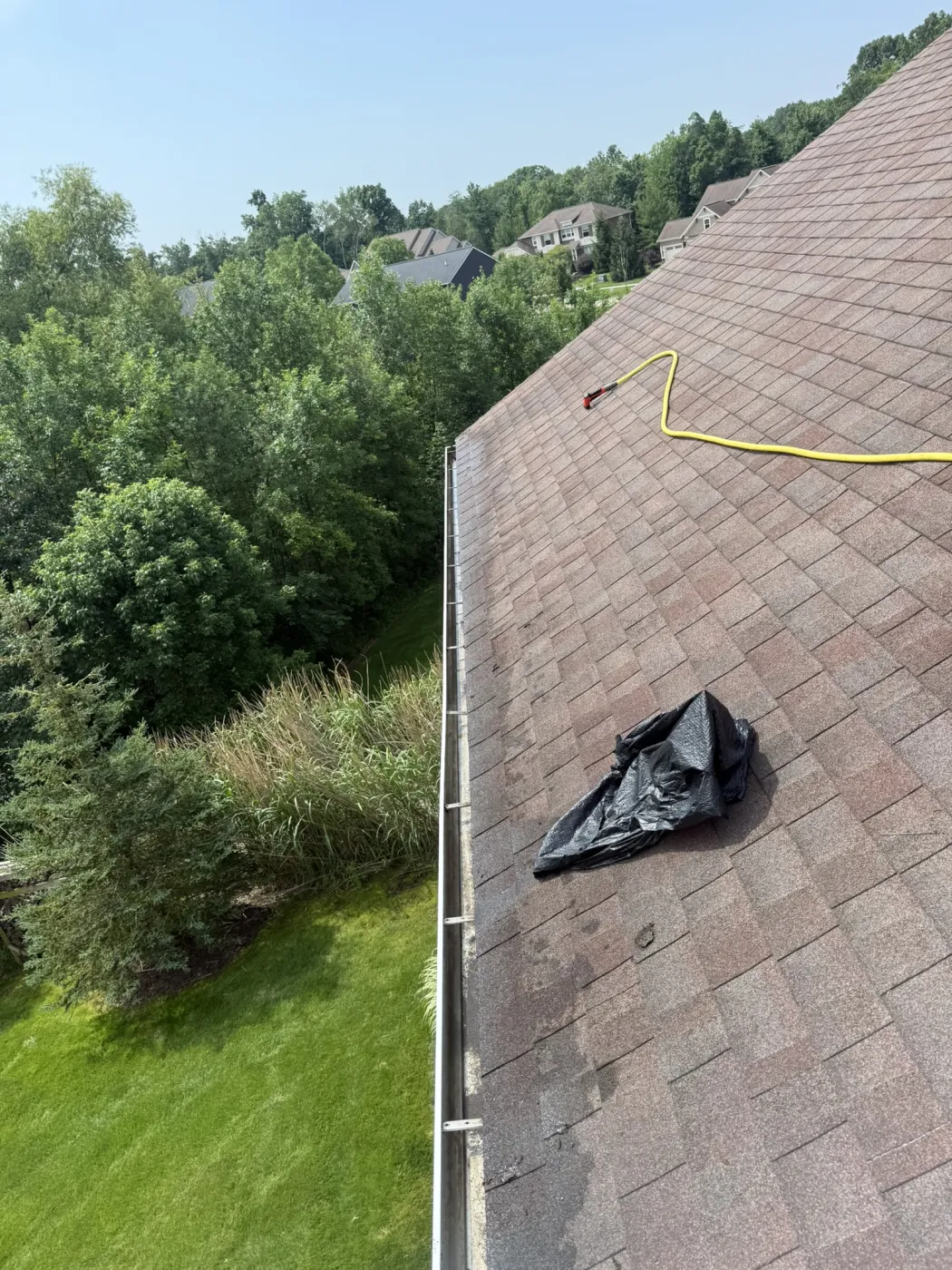 Gutter cleaning wand clearing debris on a rooftop